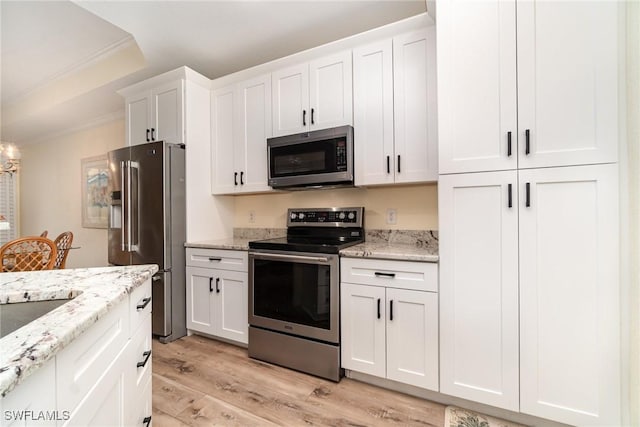 kitchen with sink, white cabinetry, light hardwood / wood-style flooring, light stone countertops, and appliances with stainless steel finishes