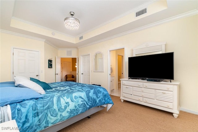 bedroom with a raised ceiling, ensuite bath, crown molding, and carpet floors