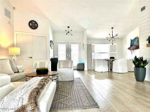 9553 Campbell Cir, Naples, FL 34109 - living room with visible vents, wood finished floors, french doors, and a chandelier