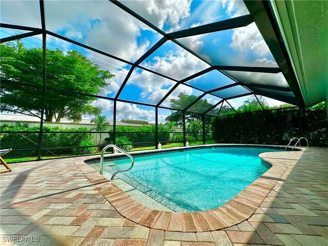 view of pool featuring a patio and glass enclosure