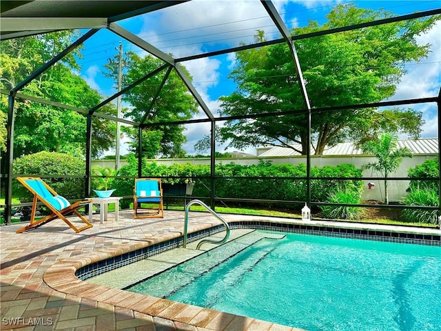 view of pool with a patio area and glass enclosure