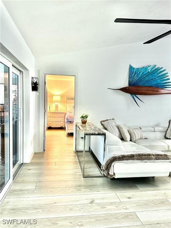 bedroom featuring ceiling fan, lofted ceiling, and light hardwood / wood-style flooring