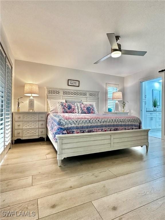 bedroom with light hardwood / wood-style floors, ceiling fan, and ensuite bathroom