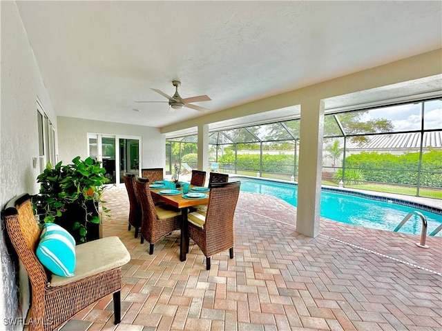 view of swimming pool featuring a patio, ceiling fan, and glass enclosure