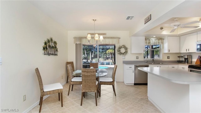 dining area with ceiling fan with notable chandelier, sink, and a wealth of natural light