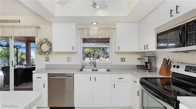 kitchen with stainless steel appliances, sink, and white cabinets