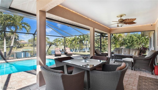 sunroom featuring a water view and ceiling fan