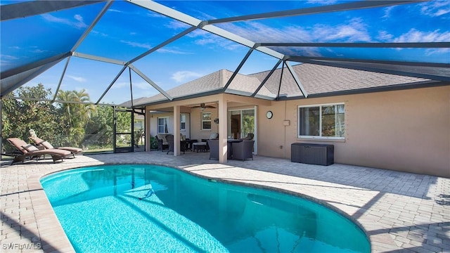 view of pool featuring ceiling fan, glass enclosure, and a patio area