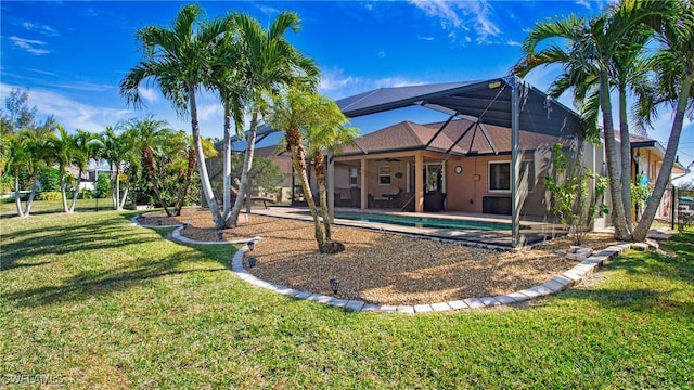 rear view of property with a lanai, a yard, and a patio area