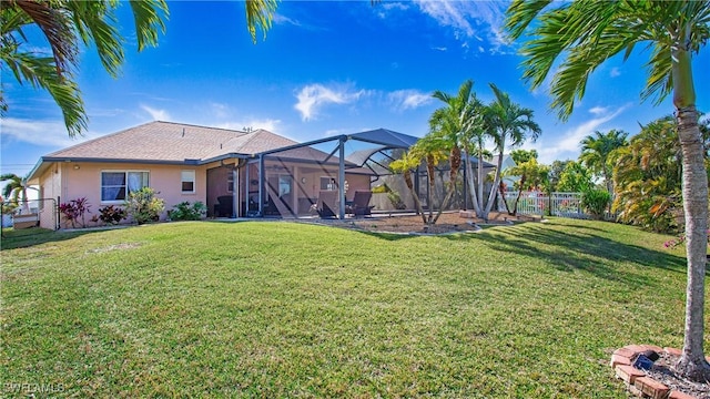 back of property with a lanai and a lawn