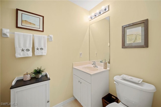 bathroom with toilet, vanity, and tile patterned flooring