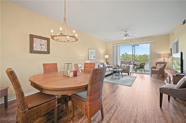 dining area with wood finished floors, a chandelier, ceiling fan, and baseboards