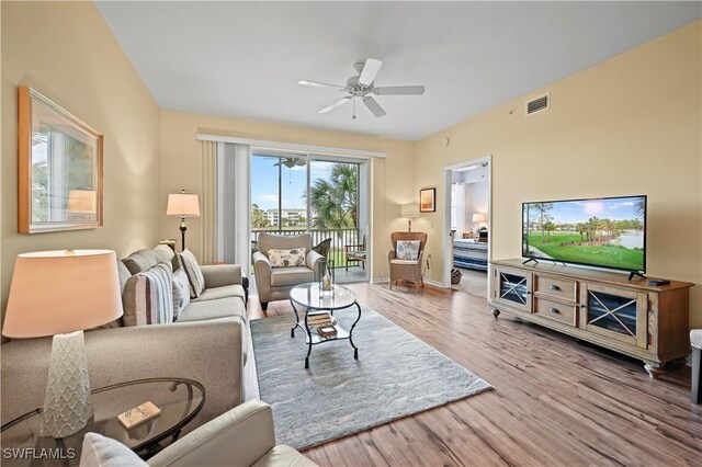 living room with light hardwood / wood-style floors and ceiling fan