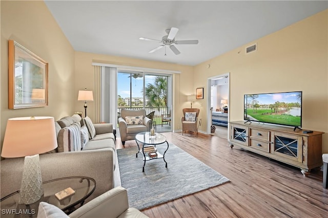living area featuring ceiling fan, wood finished floors, and baseboards