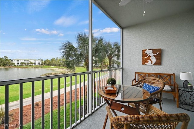 balcony featuring ceiling fan and a water view