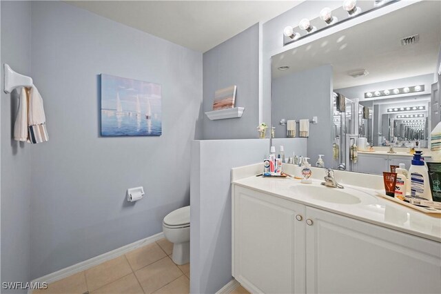 bathroom featuring toilet, vanity, and tile patterned floors