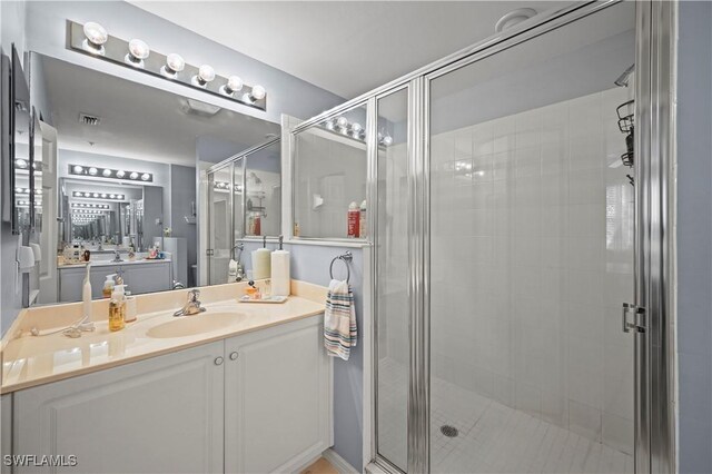 bathroom with vanity and a shower with shower door