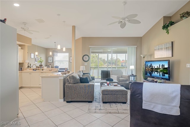 tiled living room featuring lofted ceiling, ceiling fan, a healthy amount of sunlight, and sink