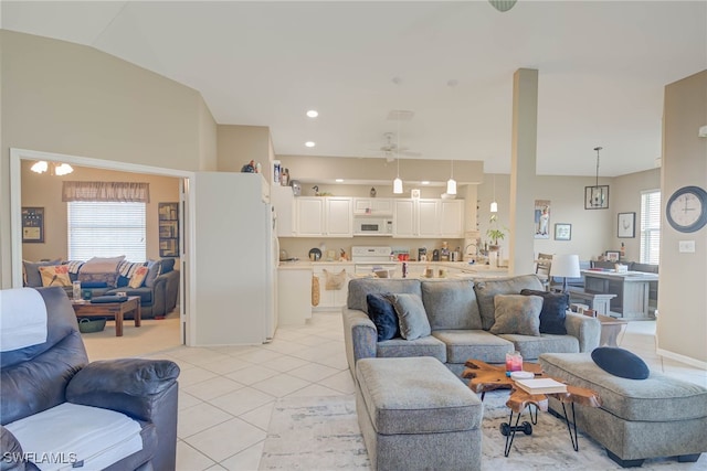 living room with lofted ceiling, ceiling fan, and light tile patterned floors