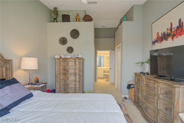 bedroom featuring connected bathroom and light carpet