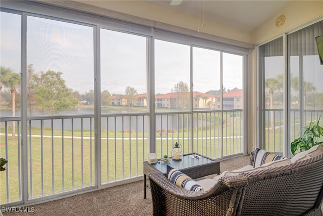 sunroom featuring a water view