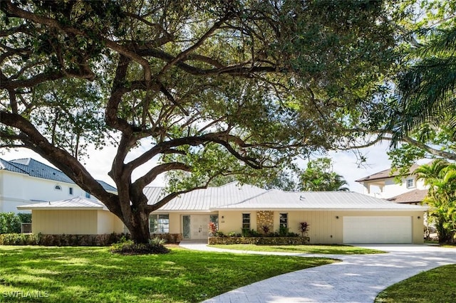 single story home with a garage and a front yard