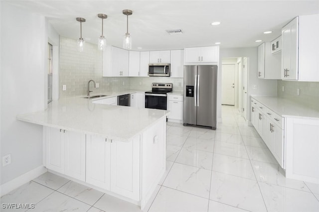 kitchen with hanging light fixtures, kitchen peninsula, white cabinets, and appliances with stainless steel finishes