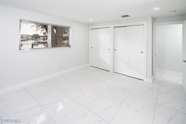 unfurnished bedroom featuring multiple closets