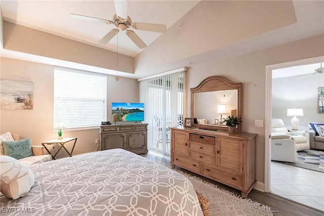 bedroom featuring multiple windows, a tray ceiling, and lofted ceiling