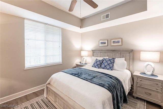 bedroom with dark hardwood / wood-style floors and ceiling fan