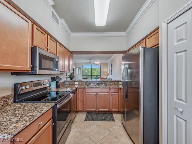 kitchen with dark stone counters, sink, crown molding, and stainless steel appliances