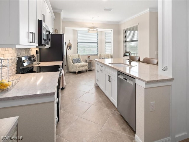 kitchen with appliances with stainless steel finishes, white cabinets, light stone counters, and sink