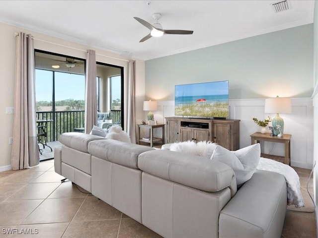 tiled living room featuring ceiling fan and crown molding