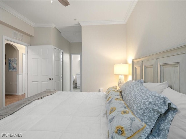 bedroom with ceiling fan, crown molding, and ensuite bath