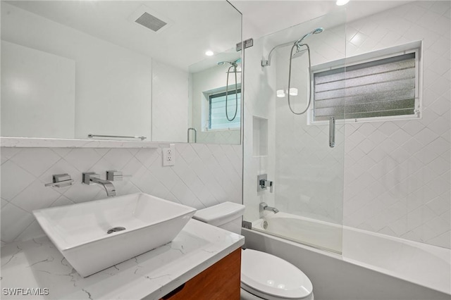 full bathroom with toilet, tile walls, enclosed tub / shower combo, and vanity