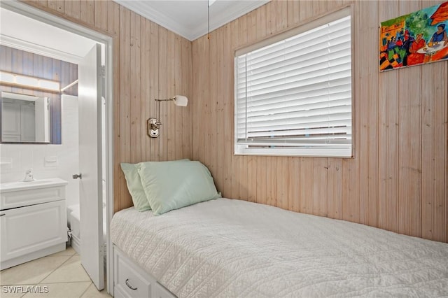 bedroom featuring light tile patterned floors, wood walls, sink, and crown molding