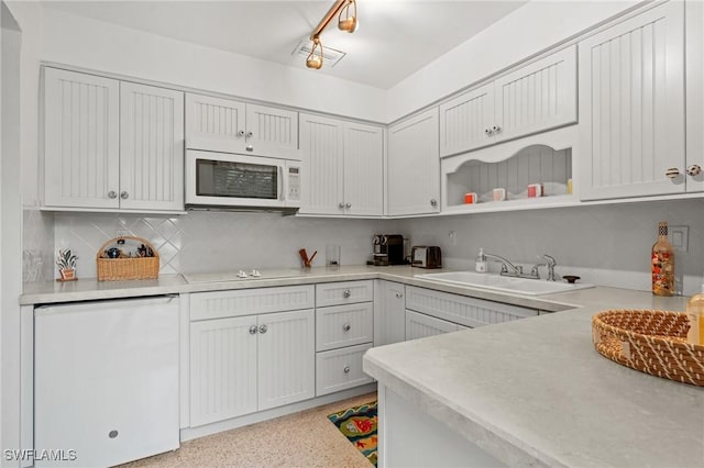 kitchen featuring white cabinetry, sink, backsplash, and white appliances