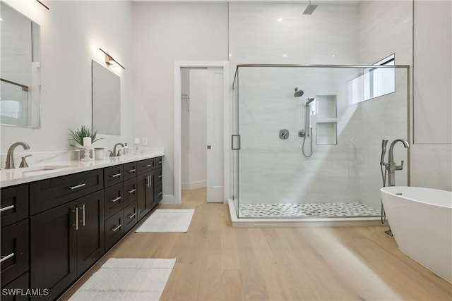 bathroom with hardwood / wood-style flooring, vanity, and separate shower and tub