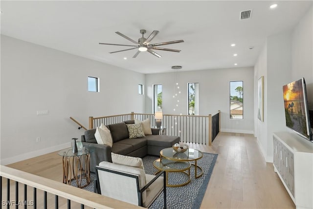 living room featuring light wood-type flooring and ceiling fan