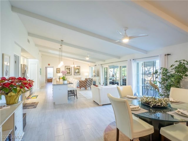 dining area with ceiling fan and vaulted ceiling with beams