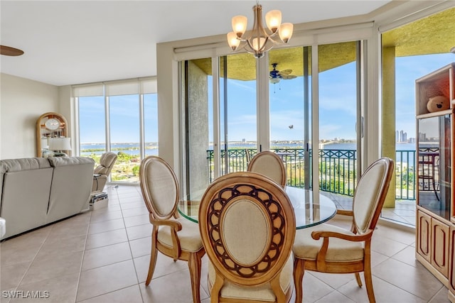 tiled dining area featuring expansive windows and ceiling fan with notable chandelier