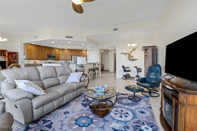 tiled living room featuring ceiling fan with notable chandelier