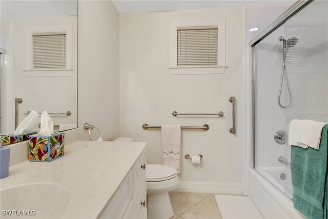 full bathroom featuring enclosed tub / shower combo, vanity, tile patterned floors, and toilet