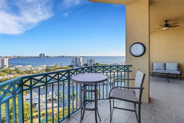 balcony with a water view and ceiling fan