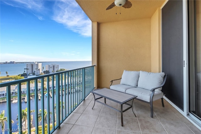 balcony with a water view and ceiling fan