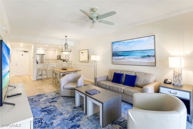 living room featuring ceiling fan, light hardwood / wood-style floors, and crown molding