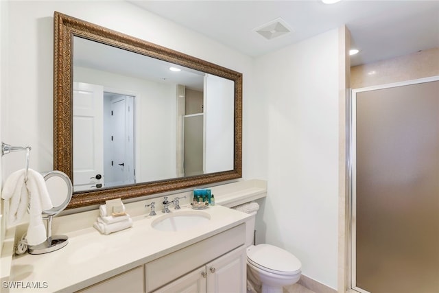 bathroom with vanity, a shower with shower door, and toilet