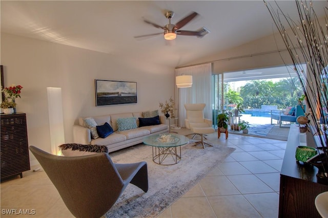 living room with ceiling fan, light tile patterned floors, and vaulted ceiling