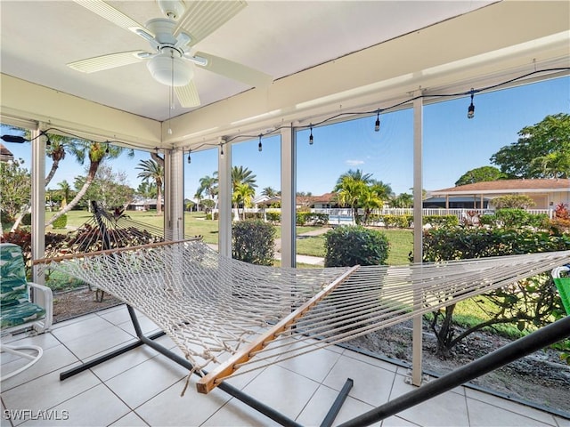 unfurnished sunroom featuring ceiling fan