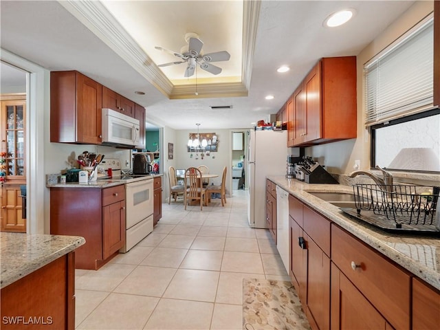 kitchen featuring white appliances, a raised ceiling, crown molding, light stone countertops, and ceiling fan